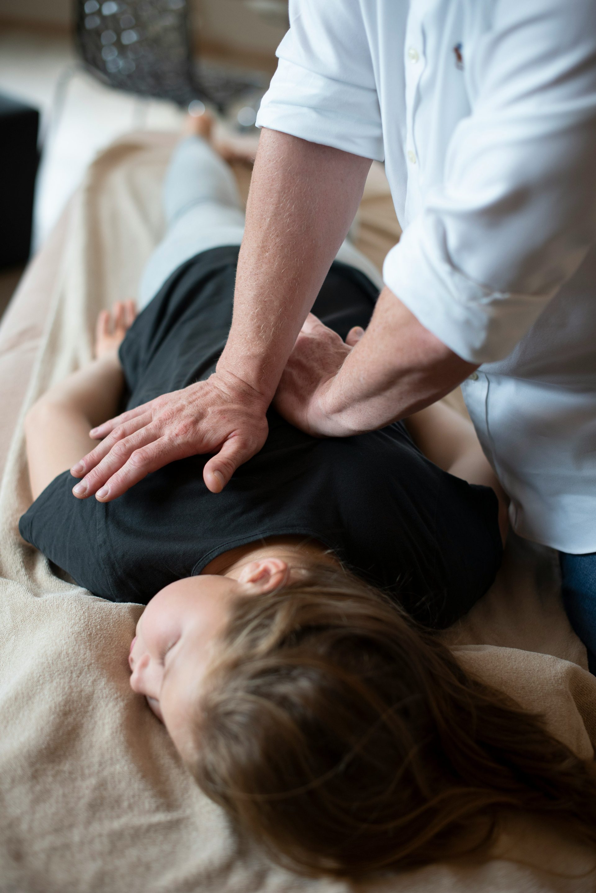 eine Frau, die von einem Mann eine Rückenmassage erhält
